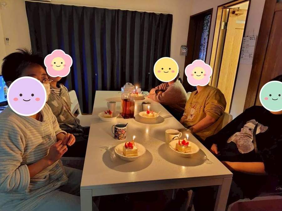 ろうそくを灯したケーキを囲む入居者さんたち