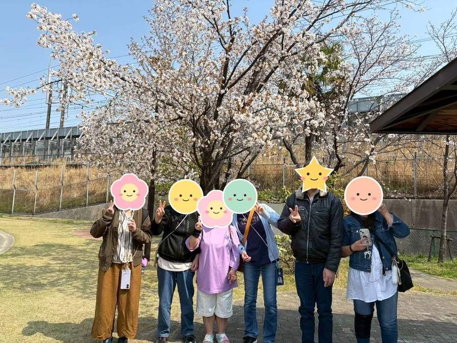 満開の桜の下でピースする入居者さんたち