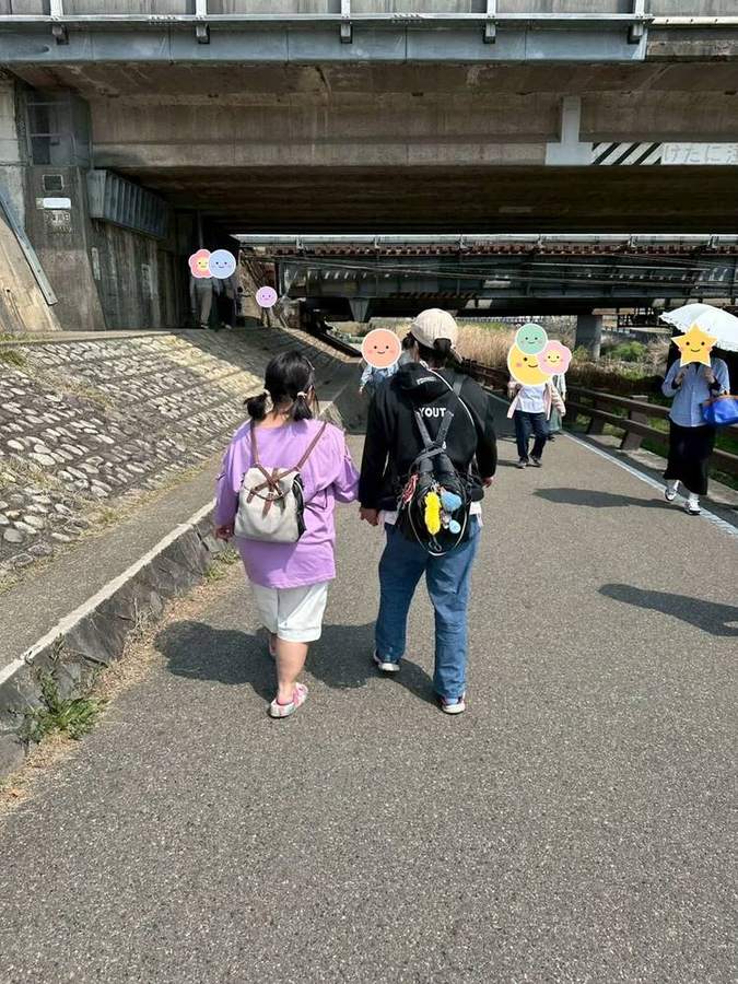 手をつないで川沿いを歩く入居者さん