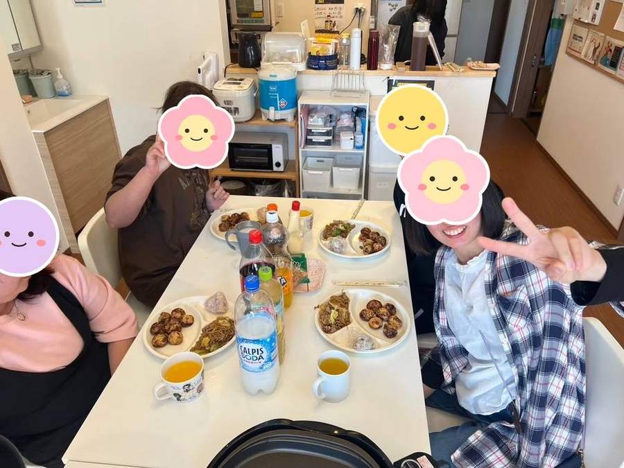 テーブルで料理を囲んでピース
