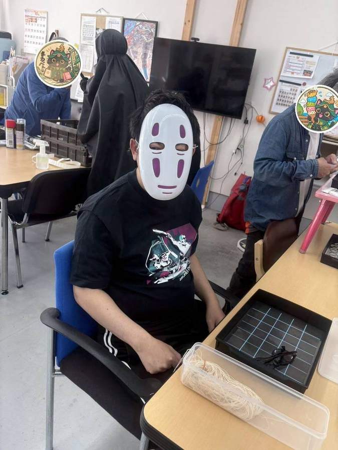 お面をつけて作業するメンバーさん