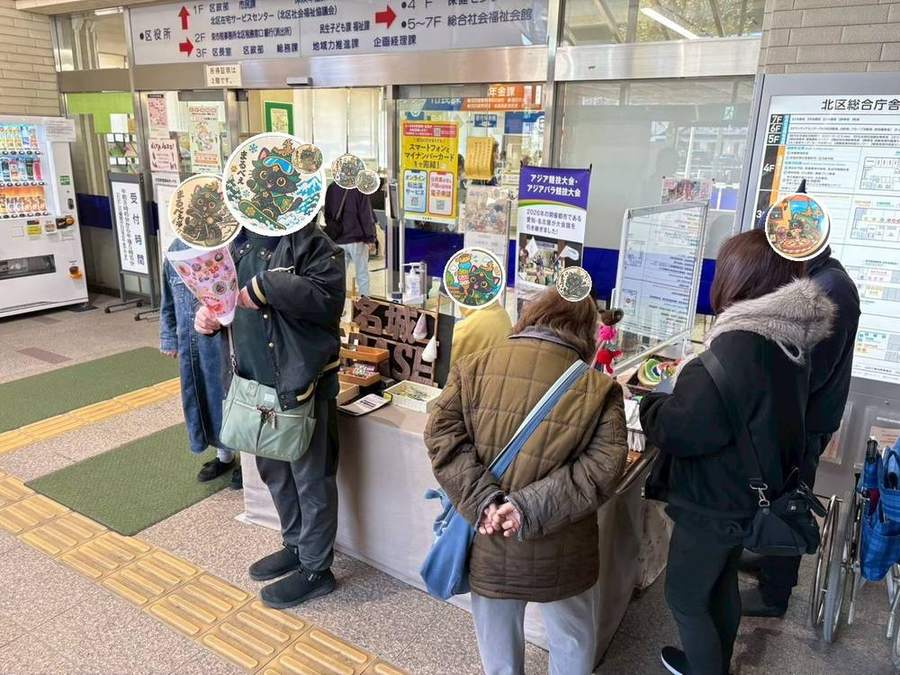 名城BASEの看板の前でお客さまをお迎えする様子