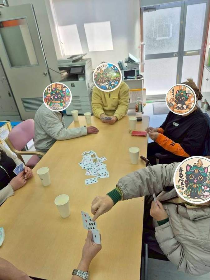 テーブルを囲んでトランプをする様子