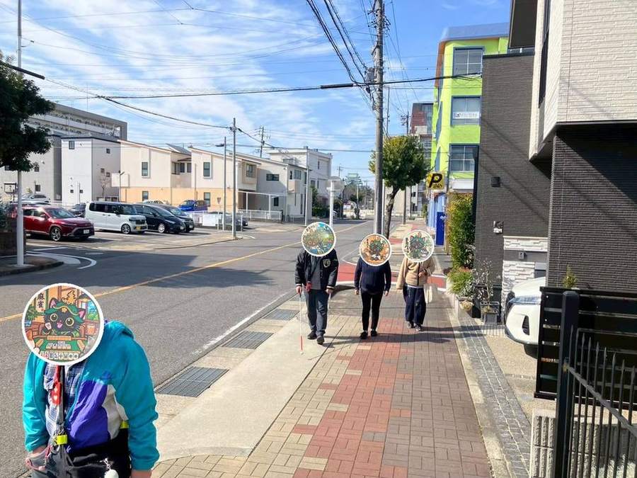 みんなで歩道を歩いて商店街へ向かう様子