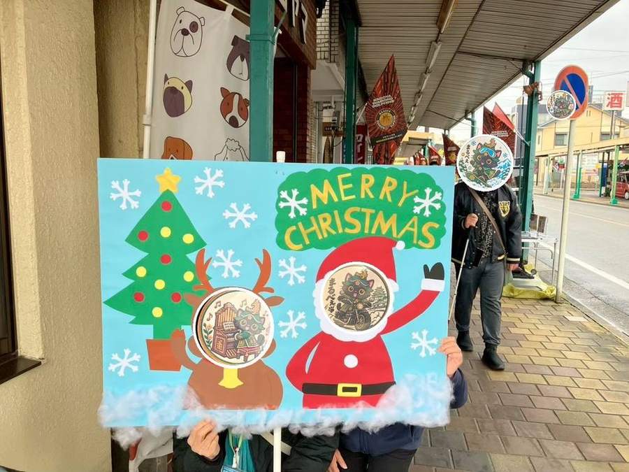 クリスマスの顔出しパネルで記念撮影する様子