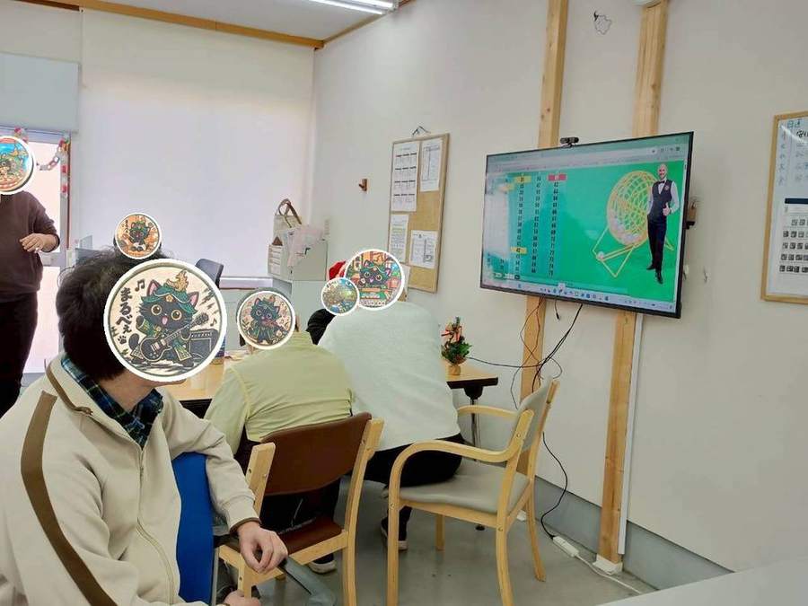 テレビ画面のビンゴを見つめるメンバーさん