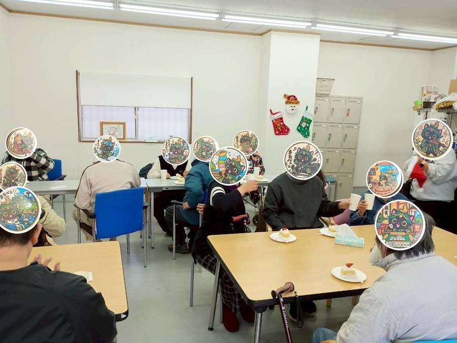 ケーキを前に紙コップで乾杯する様子